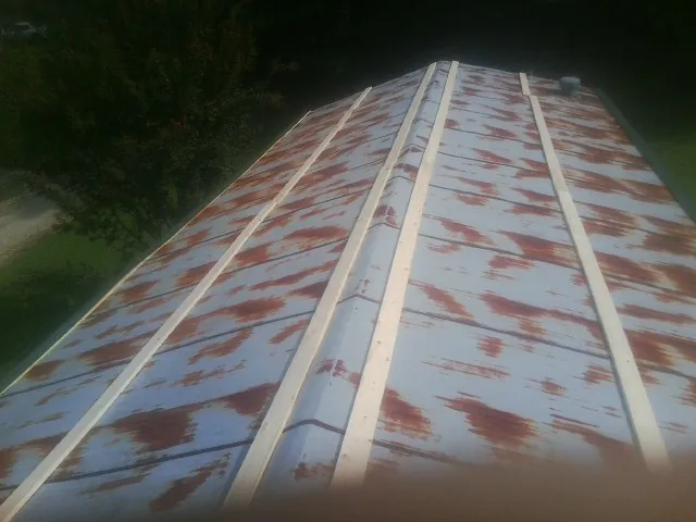 Rusted metal roof panels with new wood purlins before replacement — Storm Damage Roof Repair in Baltic by Roofing Brothers